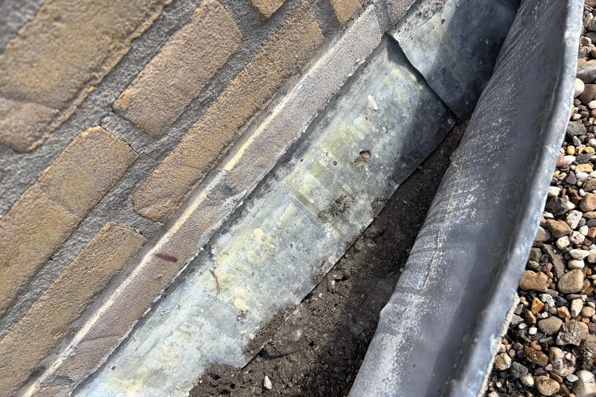 Herstelde aansluiting tussen muur en plat dak met loodwerk