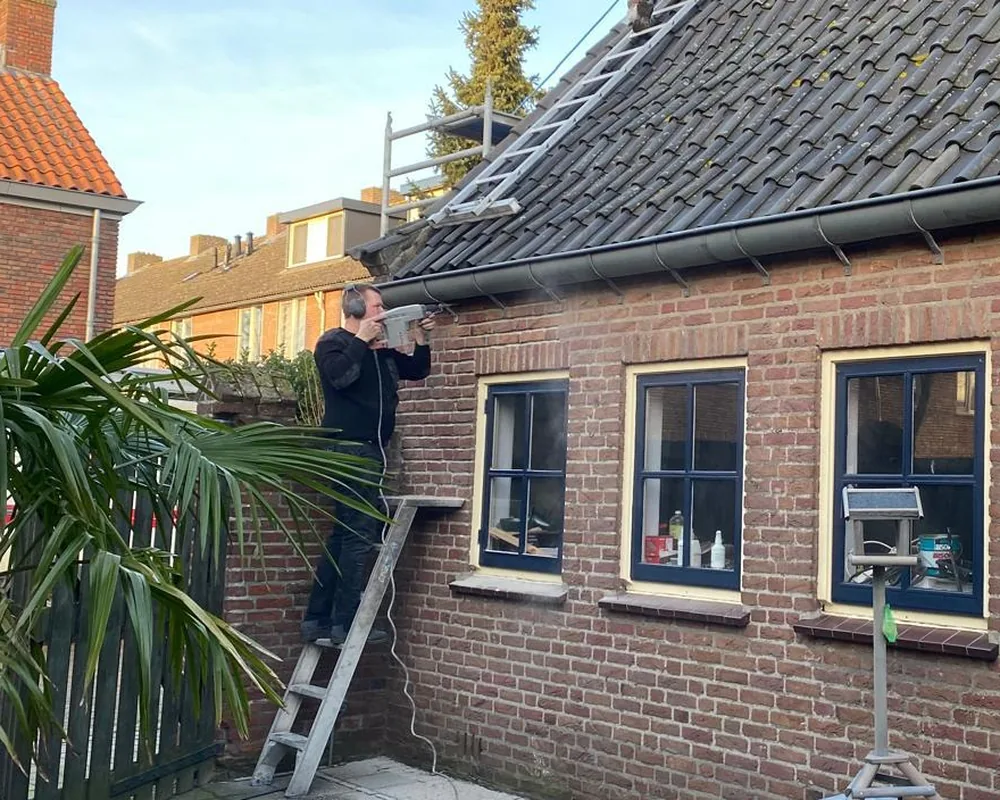 Antoine Koopmans aan het werk aan een pannendak