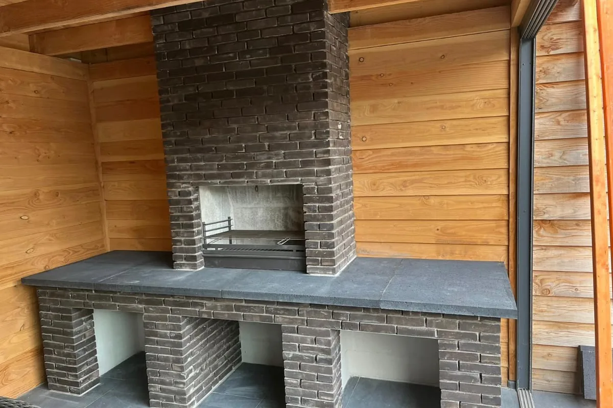 Ingemetselde haard met houten wandbekleding, vakkundig afgewerkt